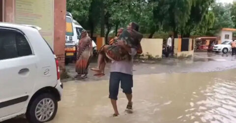 রাস্তায় জমে পানি, স্ত্রীকে কোলে নিয়ে হাসপাতালের পথে স্বামী