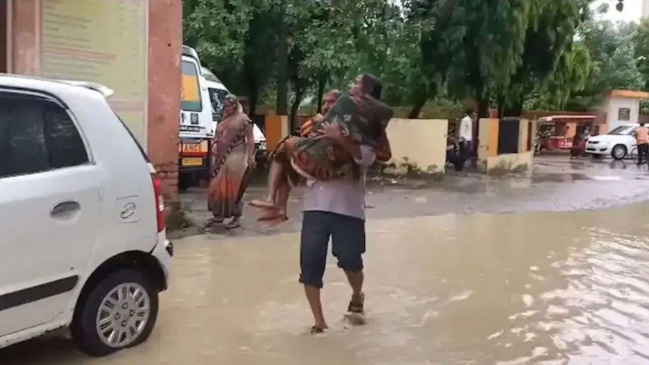 রাস্তায় জমে পানি, স্ত্রীকে কোলে নিয়ে হাসপাতালের পথে স্বামী